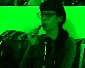 Beth, the kinky goth mistress, smokes seductively in green light