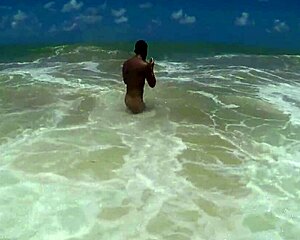 muscular bodybuilder shakes ass on beach