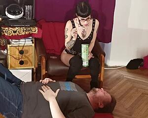 A dominatrix of the goth subculture is a slender dominatrix allowing her submissive to have her saliva injected into his mouth in a BDSM encounter