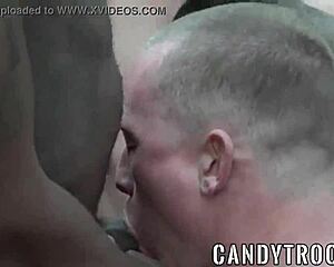 Muscular men in military uniforms engage in anal sex outdoors in a group