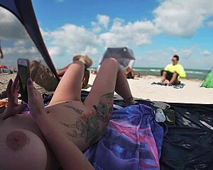Married woman flaunts her shaved pussy at a nudist beach