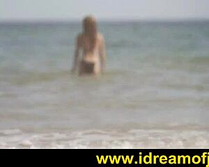 Brunette surfer on beach engages in subtle solo fingering and masturbation