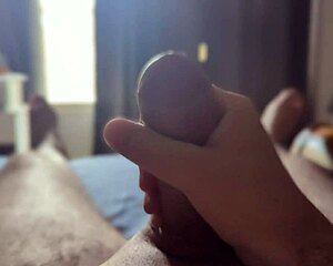 Solo guy strokes big shaft with sunlight streaming through bedroom window