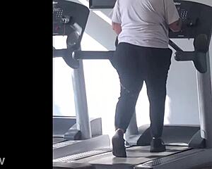 A girl with big ass is running on the treadmill
