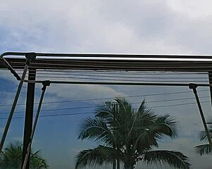 Naughty maid flashes big ass on balcony.