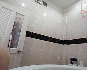the naked maid methodically cleans the toilet and shower while going without panties in the bathroom area.