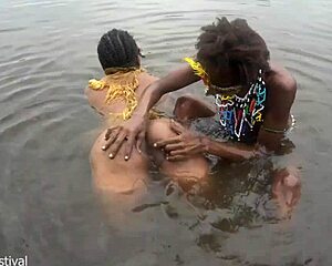 when the two lesbians from the tribe are bathing together in the village river