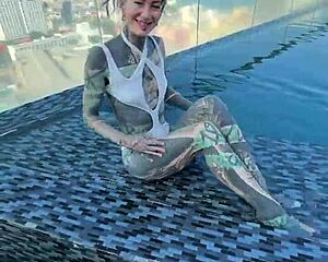 bikini model with feettattoo lounges by pattaya rooftop pool