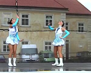 Two nice majorettes showcase cheerleading skills side by side