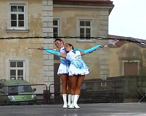 Two nice majorettes showcase cheerleading skills side by side