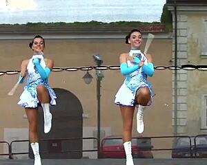 Two nice majorettes showcase cheerleading skills side by side