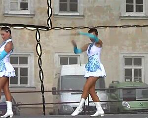 Two nice majorettes showcase cheerleading skills side by side