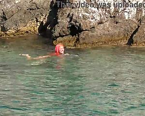 naked girl splashing around in blue water