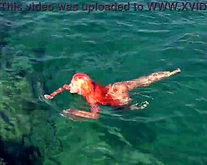 naked girl splashing around in blue water