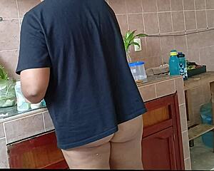 Chubby stepmom washes dishes and cleans kitchen