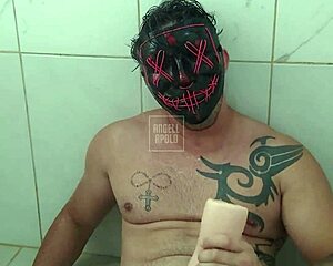 A masked tattooed man showers alone plays with toy to climax