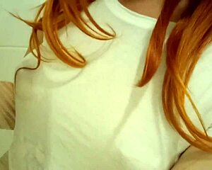 A redhead teen relaxes in the bath.