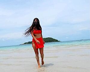Pretty tanned brunette in orange bikini flashes fingering pussy publicly on beach?