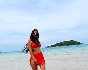 Pretty tanned brunette in orange bikini flashes fingering pussy publicly on beach?