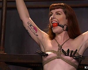 A gagged redhead gets her throat deeply fucked while bound in rough group bdsm.