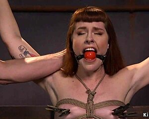 A gagged redhead gets her throat deeply fucked while bound in rough group bdsm.