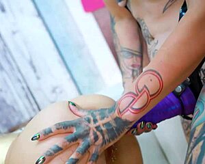 Tattooed lesbian fucks her tattoo girl friend with strapon and pussy fisting